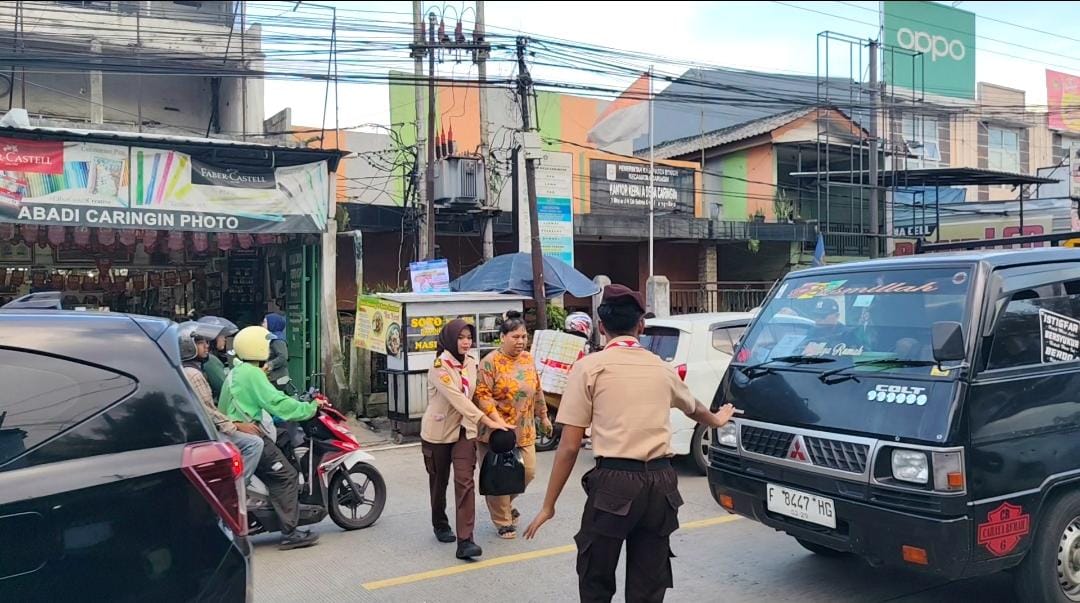 Pramuka Caringin Bantu Amankan Penyeberangan Saat Warga Berburu Takjil