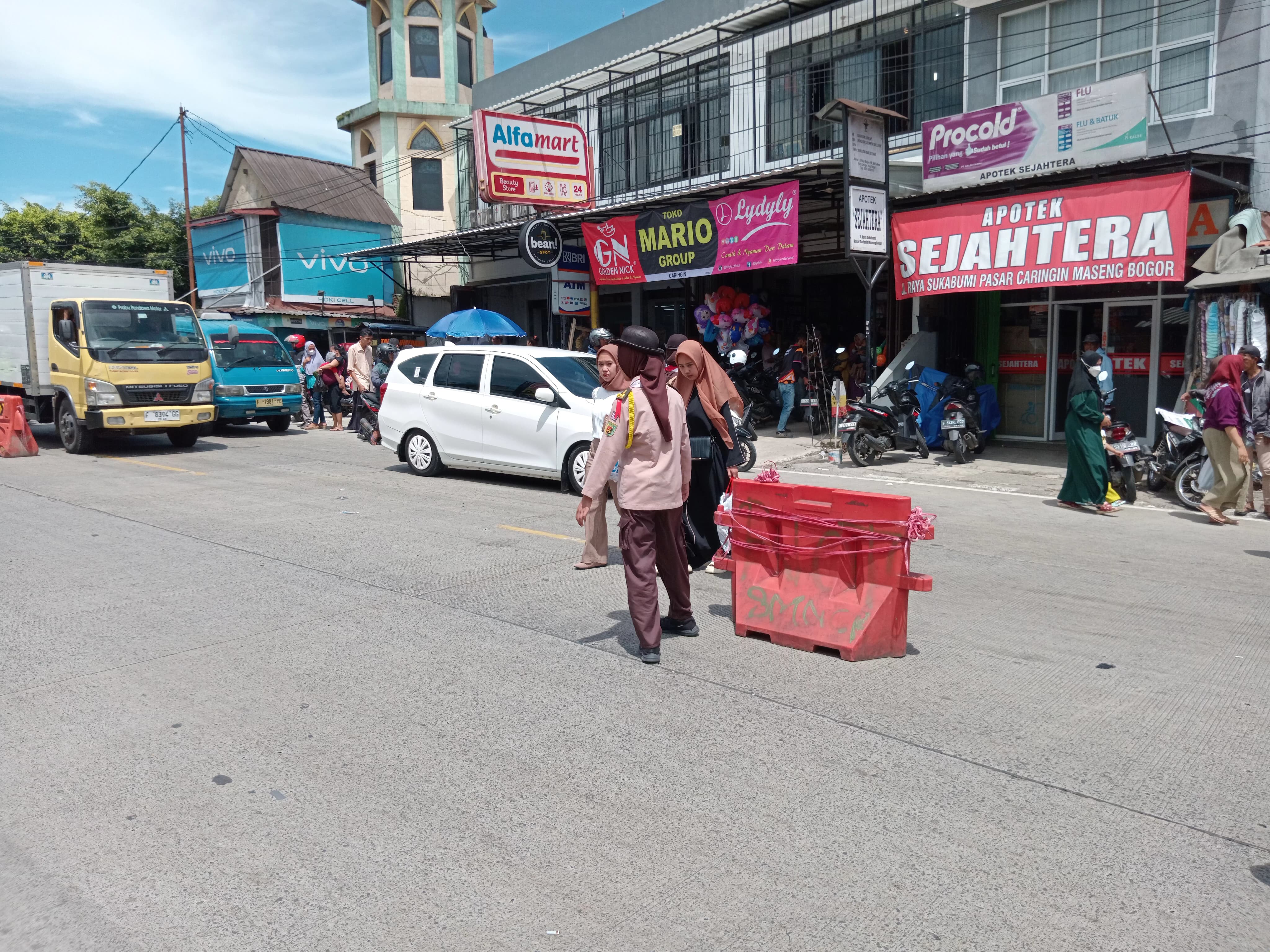Di Bawah Terik Matahari, Pramuka Caringin Tetap Sigap Bantu Warga di Simpang Pasar